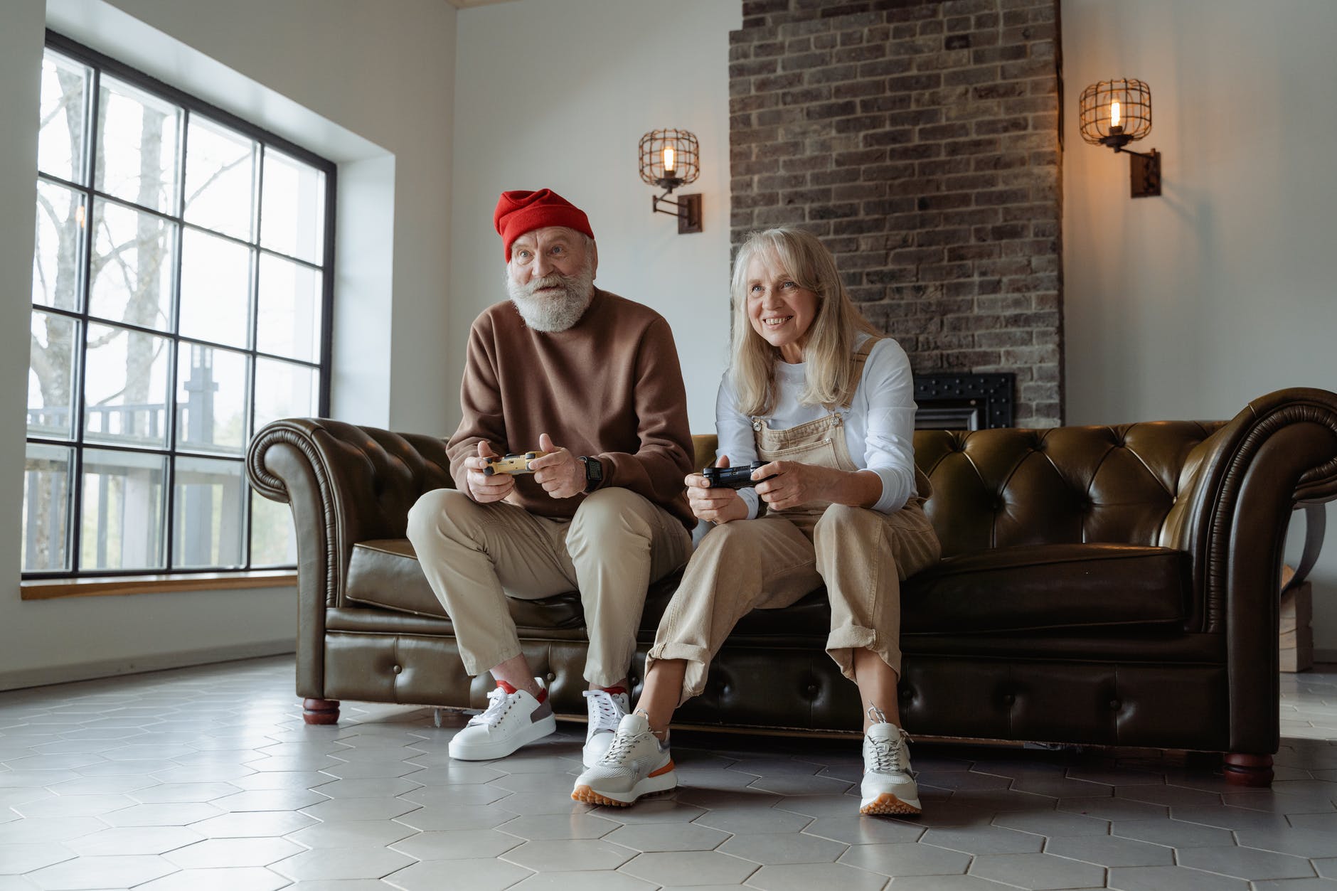 man and woman sitting on brown leather couch