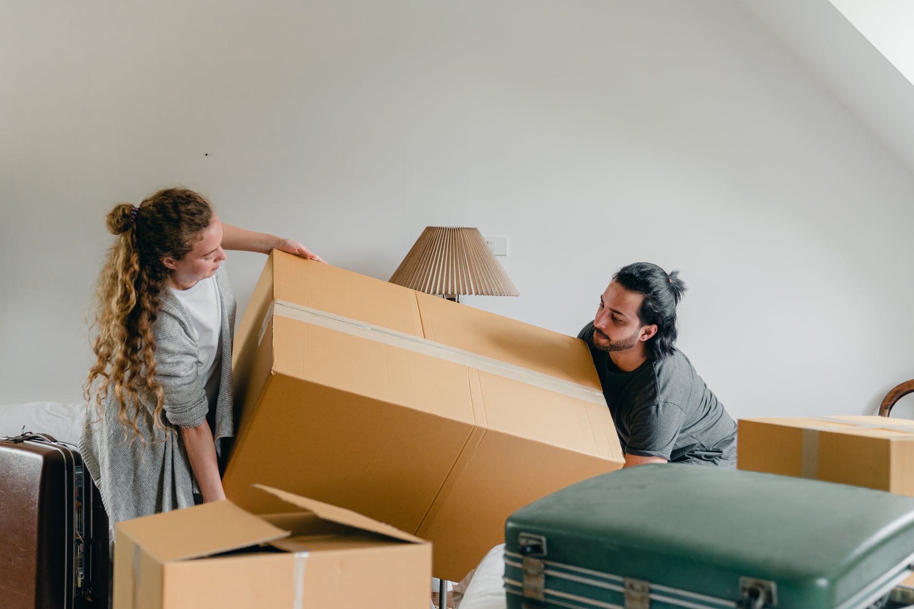 man and woman carrying carton box